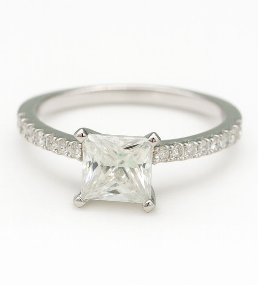 Silver ring with a princess-cut diamond on a white background